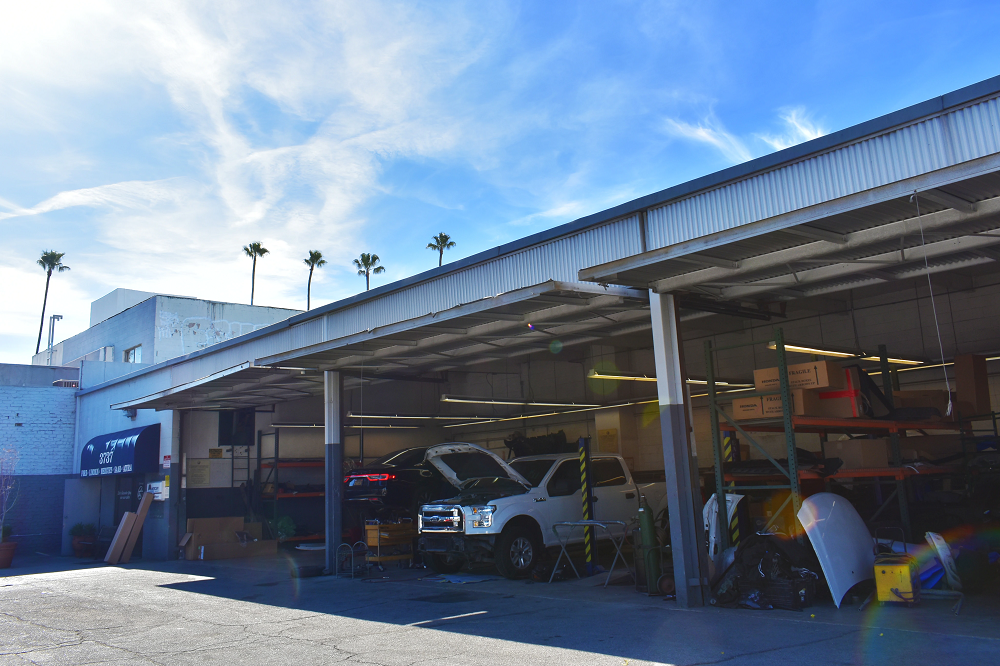 The outside of the collision center with the garage doors open